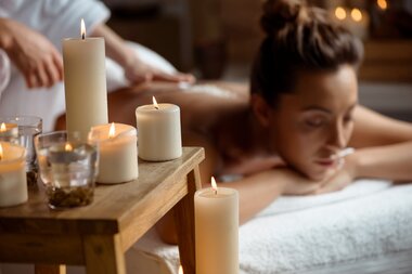 Junge Dame entspannt sich hinter Kerzen im Spa Salon | © Freepik